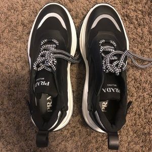 Prada Pegasus lace up sneakers in leather & nylon.